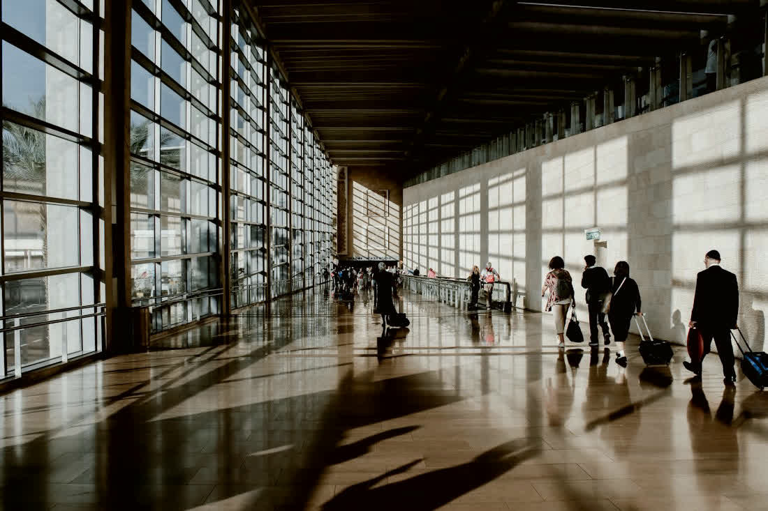 Travellers walking through a bright airport