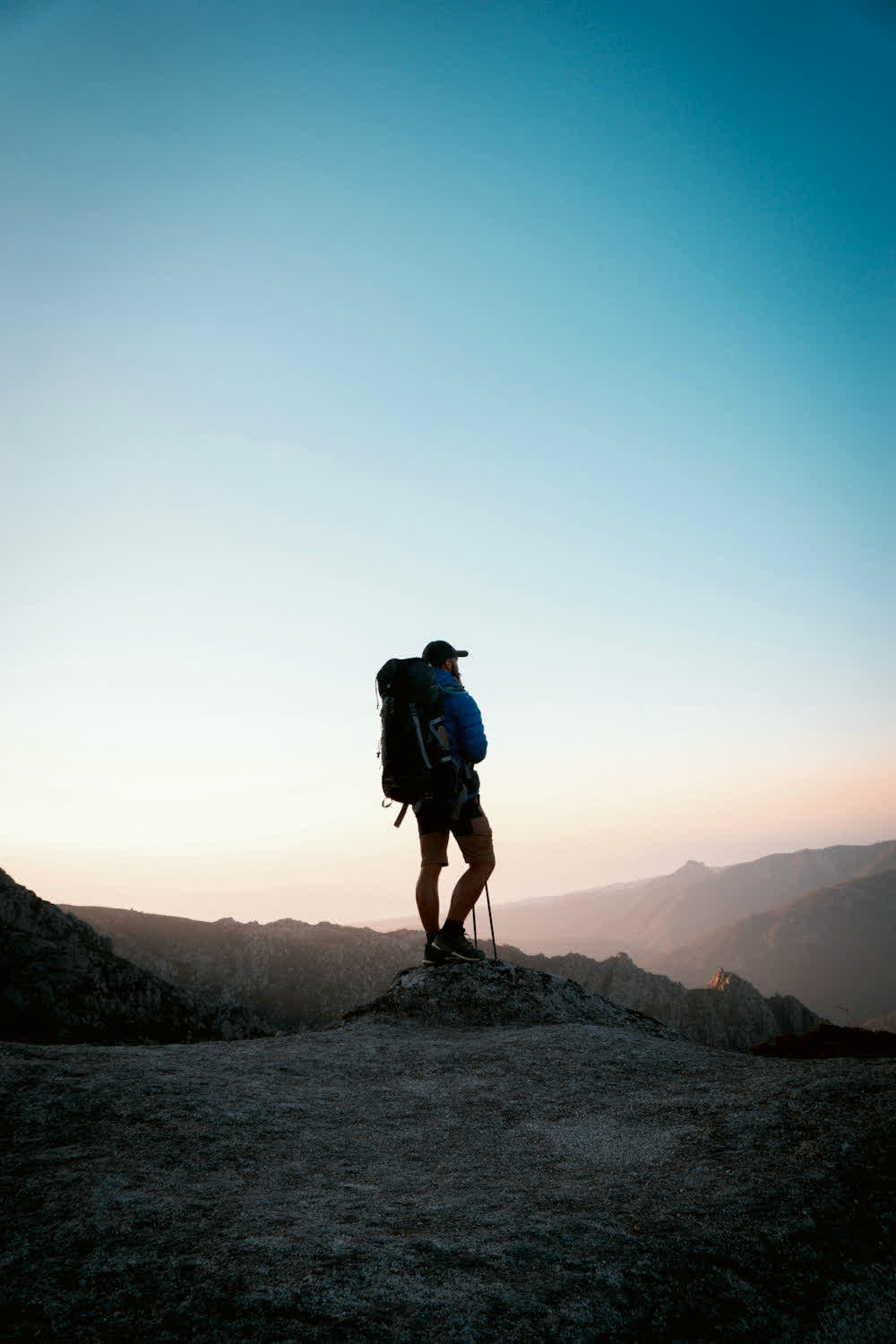 A hiker on a mountain at sunset