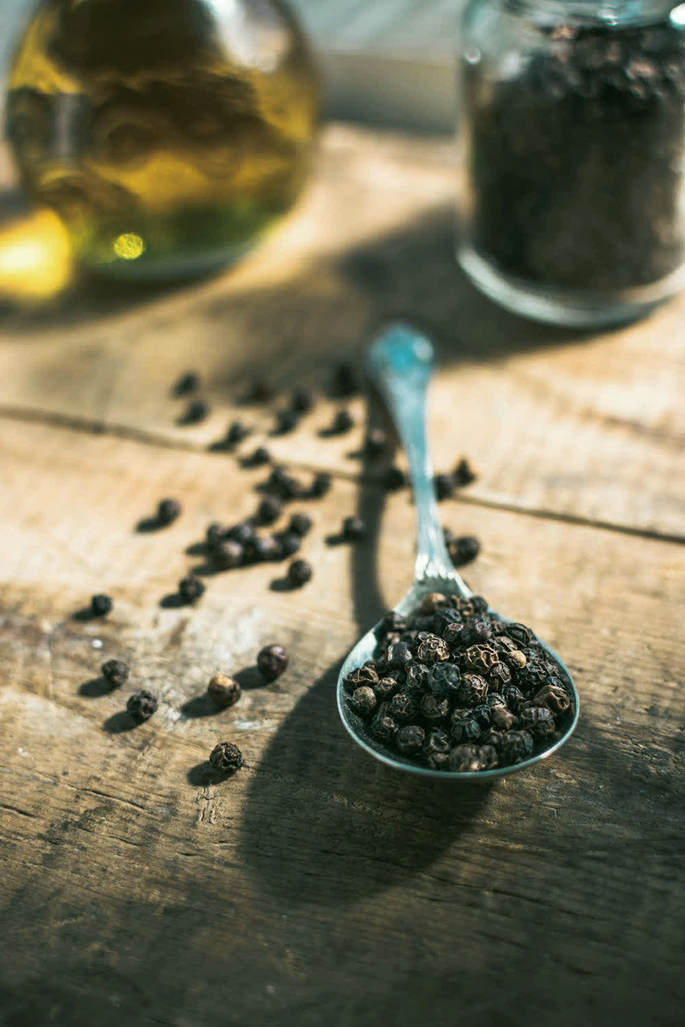 Black peppercorns on a spoon